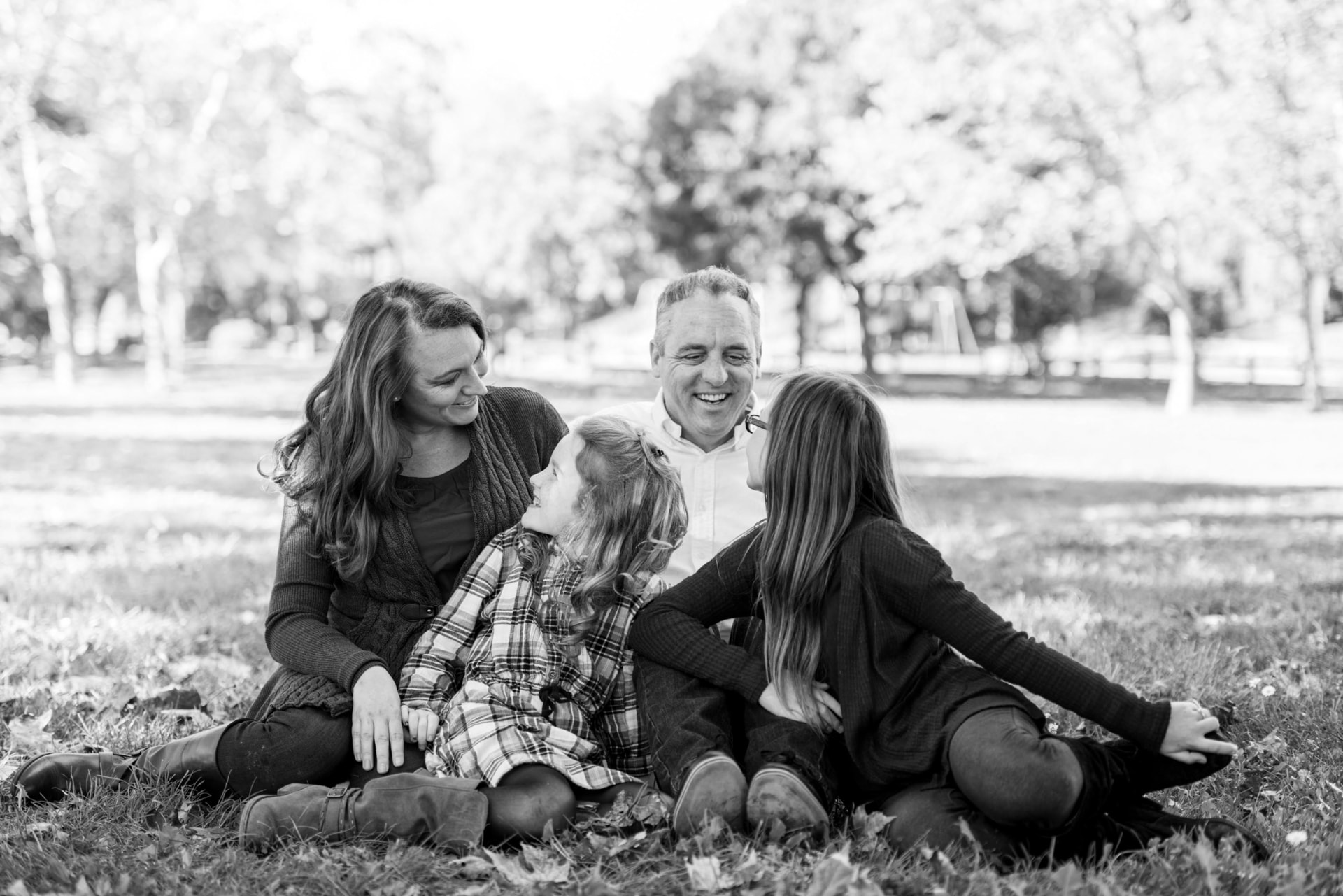 Family sitting together in the grass, laughing